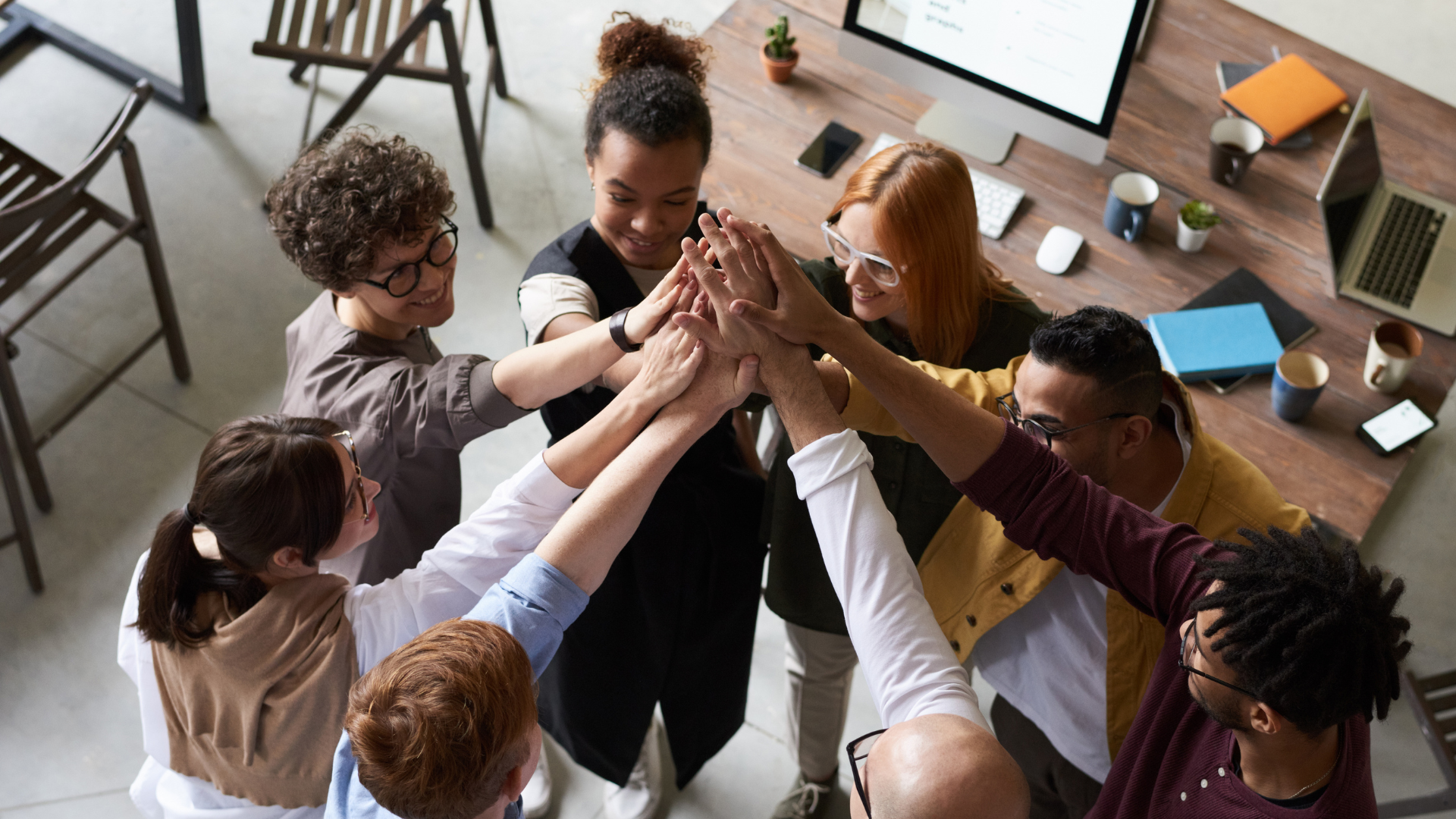 Kansainvälisiä ihmisiä, jotka pitävät ylhäällä käsiä yhdessä.