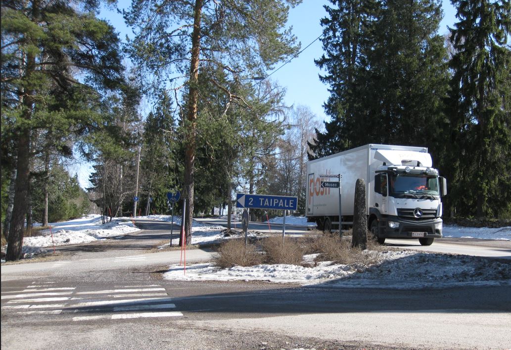 Postin kuljetusauto ohittamassa risteystä missä kyltti "2 Taipale ". 