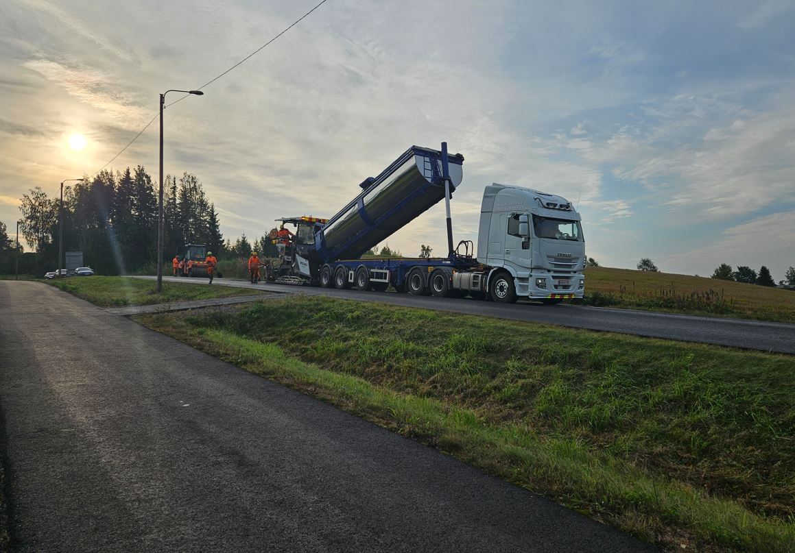Kuorma-auton lavalta lasketaan asfalttia tielle.