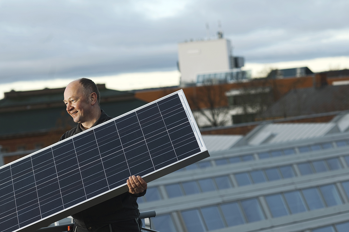 Aurinkopaneelien asentaja katolla.